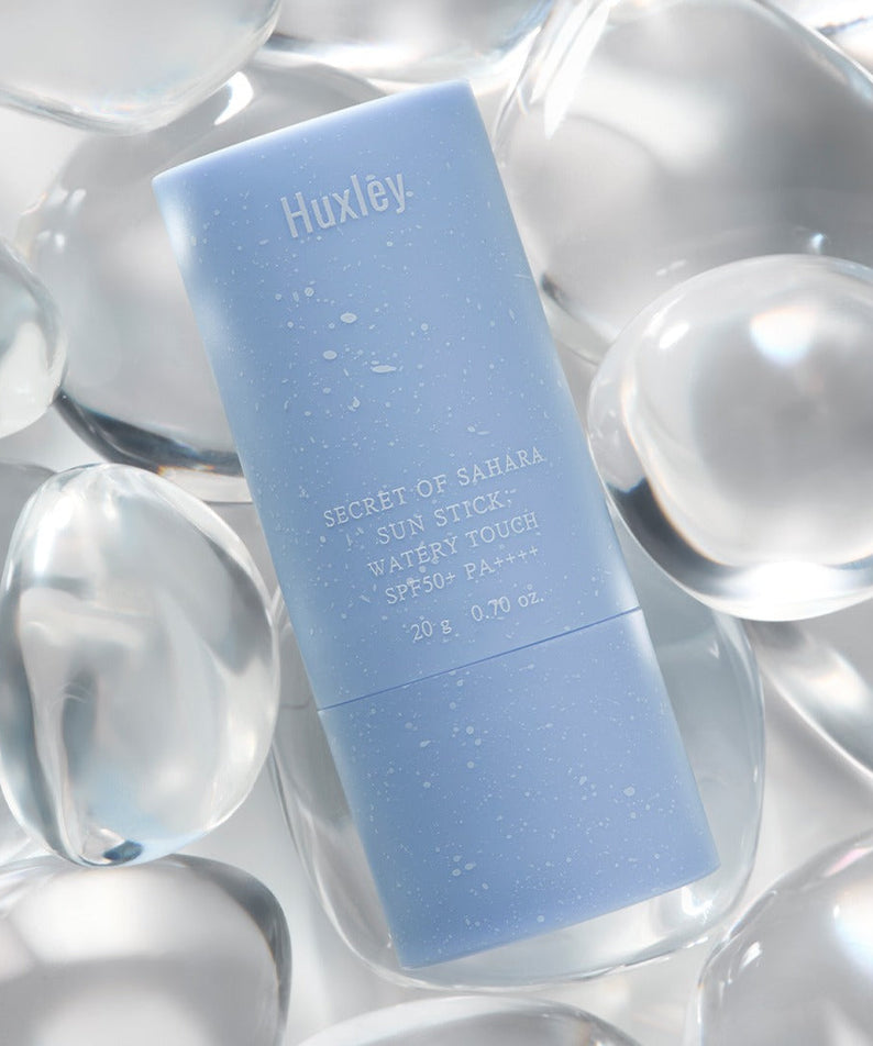 HUXLEY Sun Stick Watery Touch 20g on crystal background