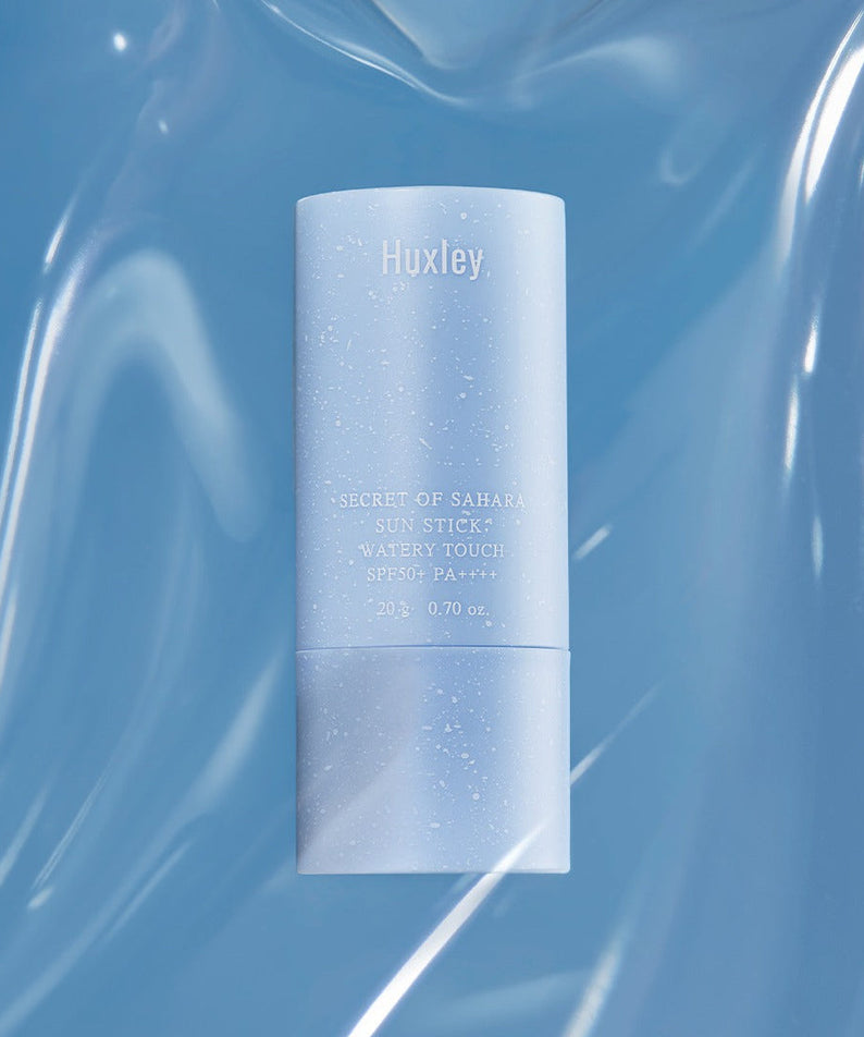HUXLEY Sun Stick Watery Touch 20g displayed on a reflective surface, showcasing its sleek design and SPF protection.