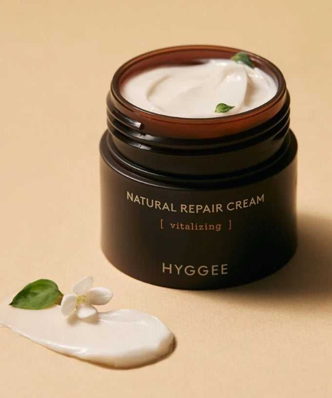 HYGGEE Nature Repair Cream 50ml jar with cream texture and plant elements on beige background.