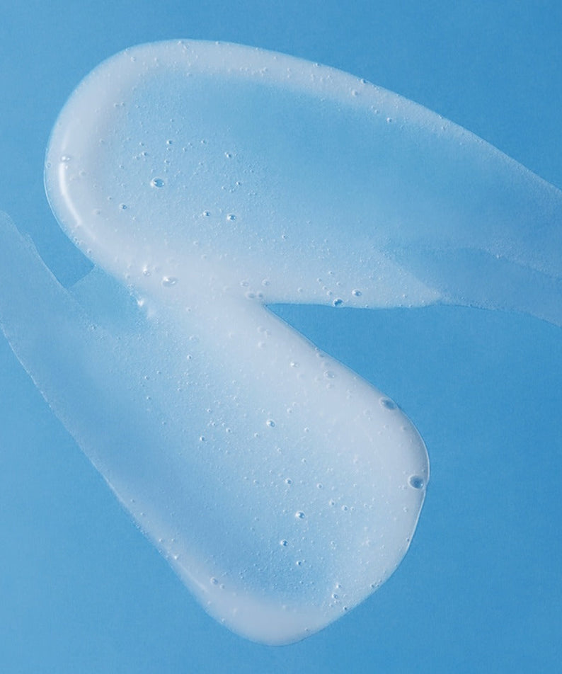 Texture of ILLIYOON Ceramide Ato 5.0 Gentle Skin Cleanser 400ml against a blue background.