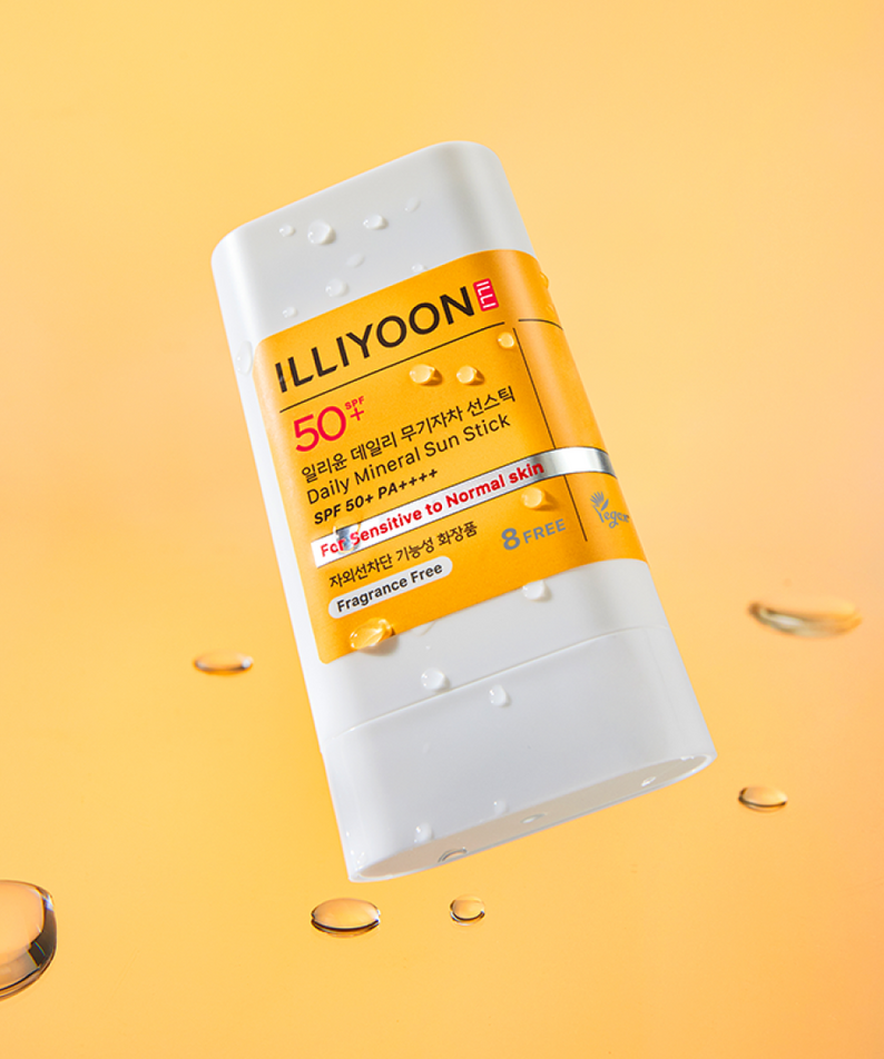 ILLIOYOON Daily Weaponless Sun Stick 20g on a glossy orange background with water droplets, highlighting sensitive skin use.