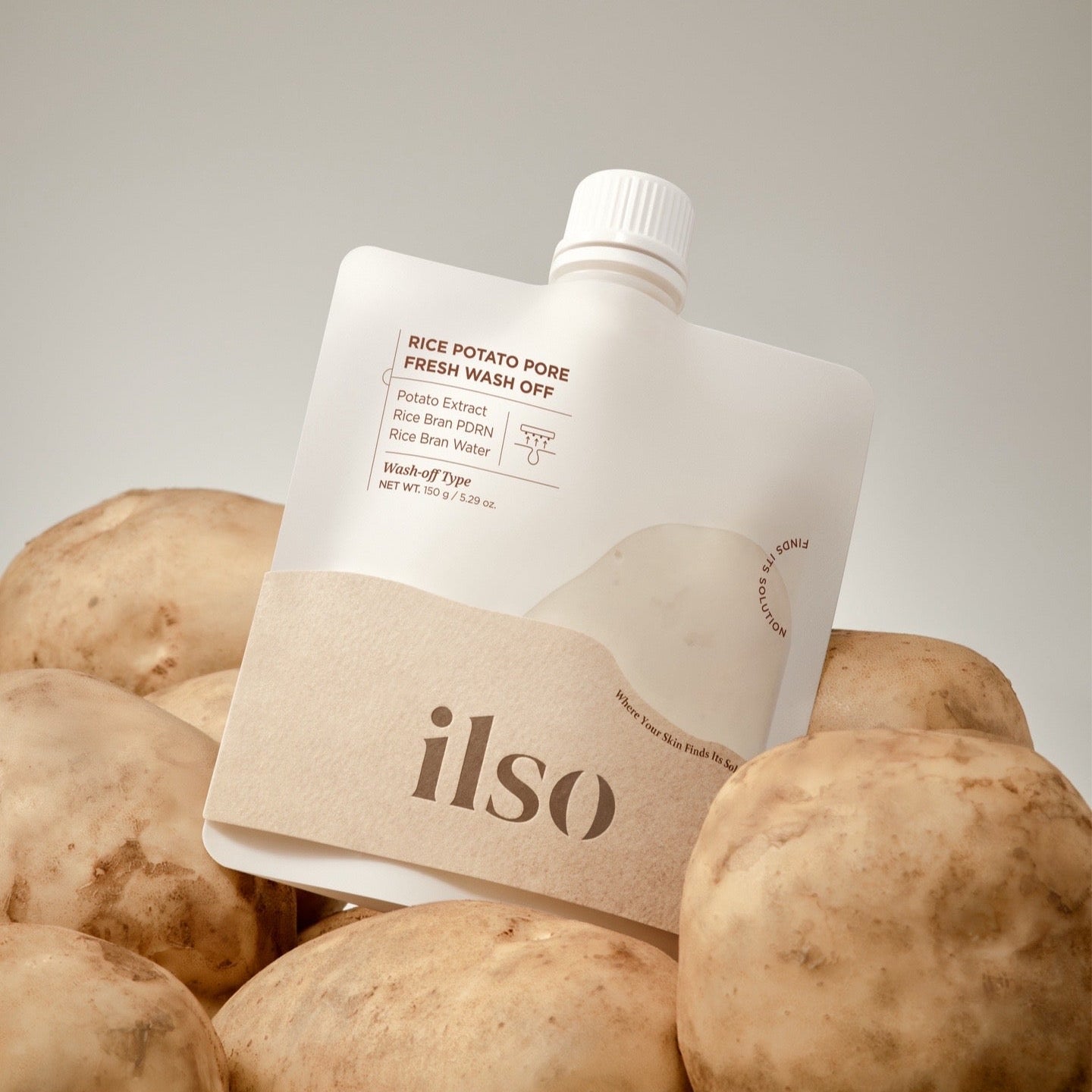 ILSO Rice Potato Pore Fresh Wash-Off 150g skincare product with natural ingredients, surrounded by potatoes.