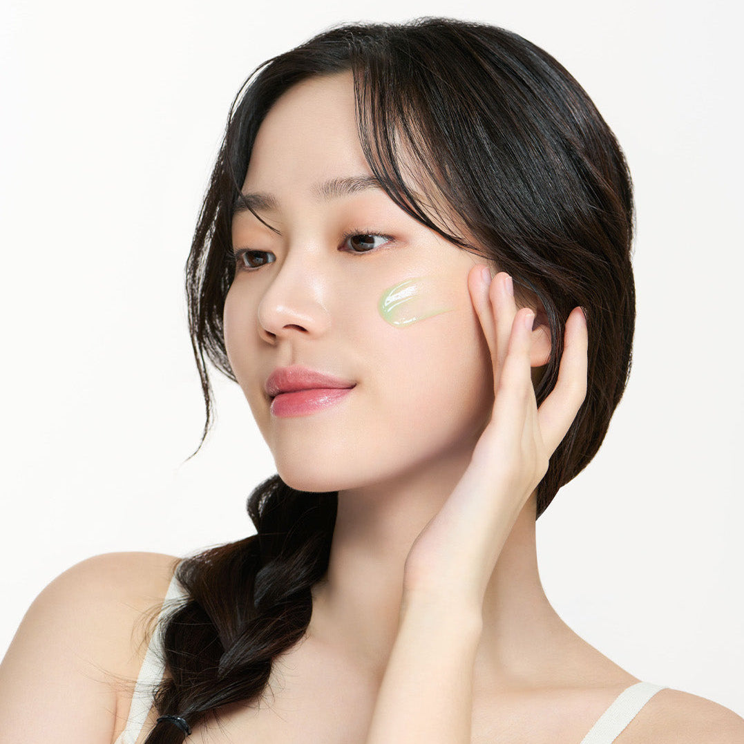 Model applying I'M FROM Mugwort Fluid Cream 50ml to her face