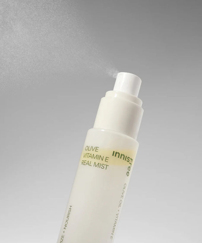 INNISFREE Olive Vitamin E Real Oil Mist 75ml in a white spray bottle with misting effect against a gray background.