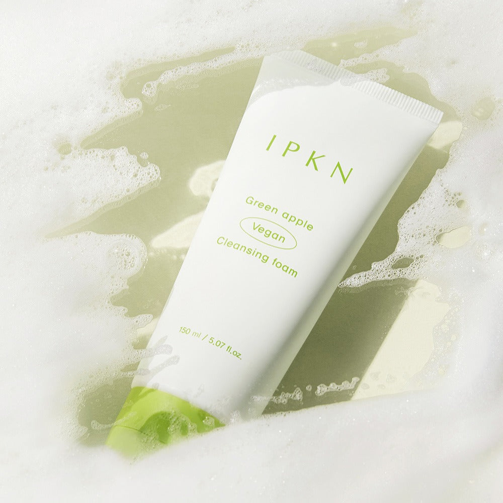 IPKN Green Apple Vegan Cleansing Foam 150ml lying on foam, showcasing the product packaging.