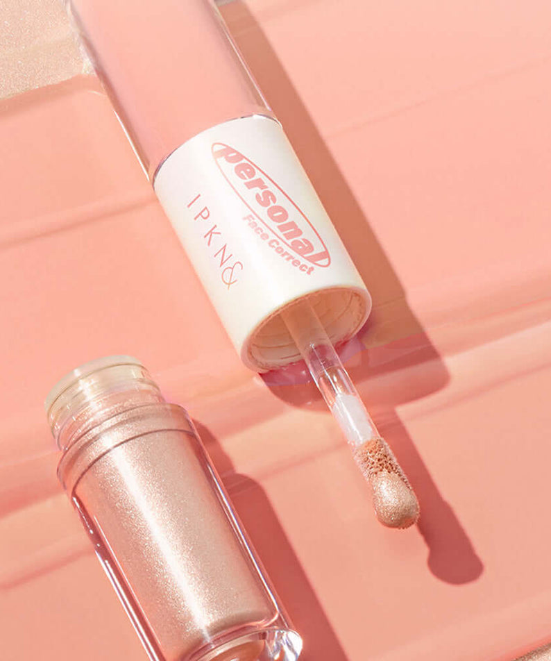 IPKN Personal Tone Cheek Lighter Duo (Warm Lighter) with applicator and open container on peach background