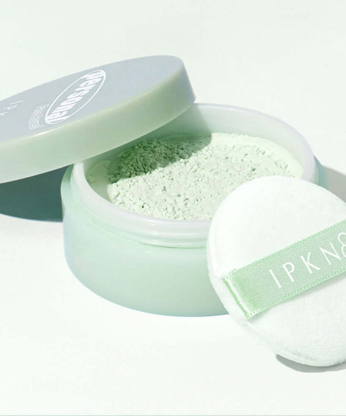 IPKN Personal Tone Correcting Powder (Green) with applicator in an open container, showcasing smooth texture and green color.