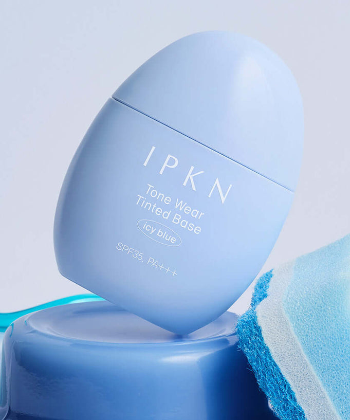 IPKN Tone Wear Tinted Base Icy Blue SPF35 PA++ on a blue background with matching fabric accent