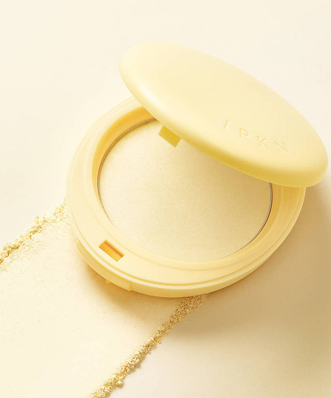 Open compact of IPKN Tonewear Primer Pact 7.5g with powder texture on beige background.