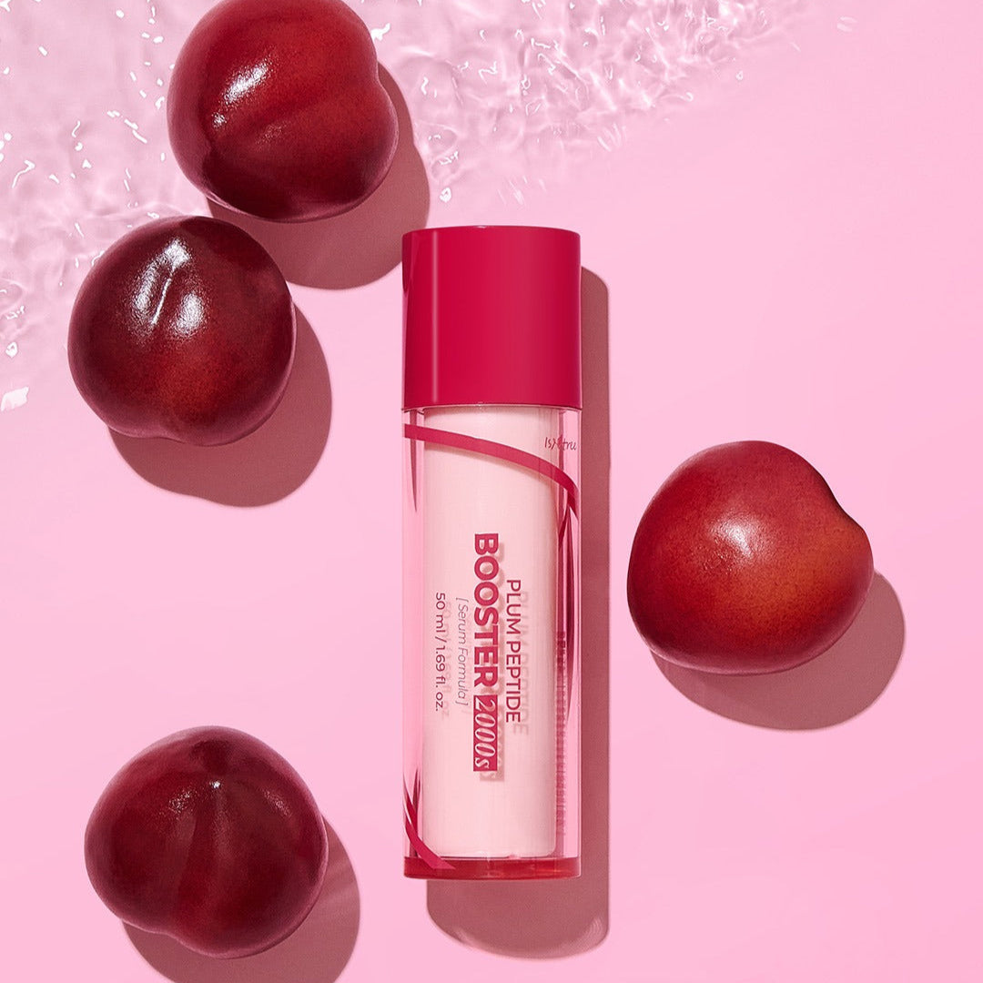 ISNTREE Plum Peptide Booster 2000s 50ml bottle surrounded by fresh plums on a pink background