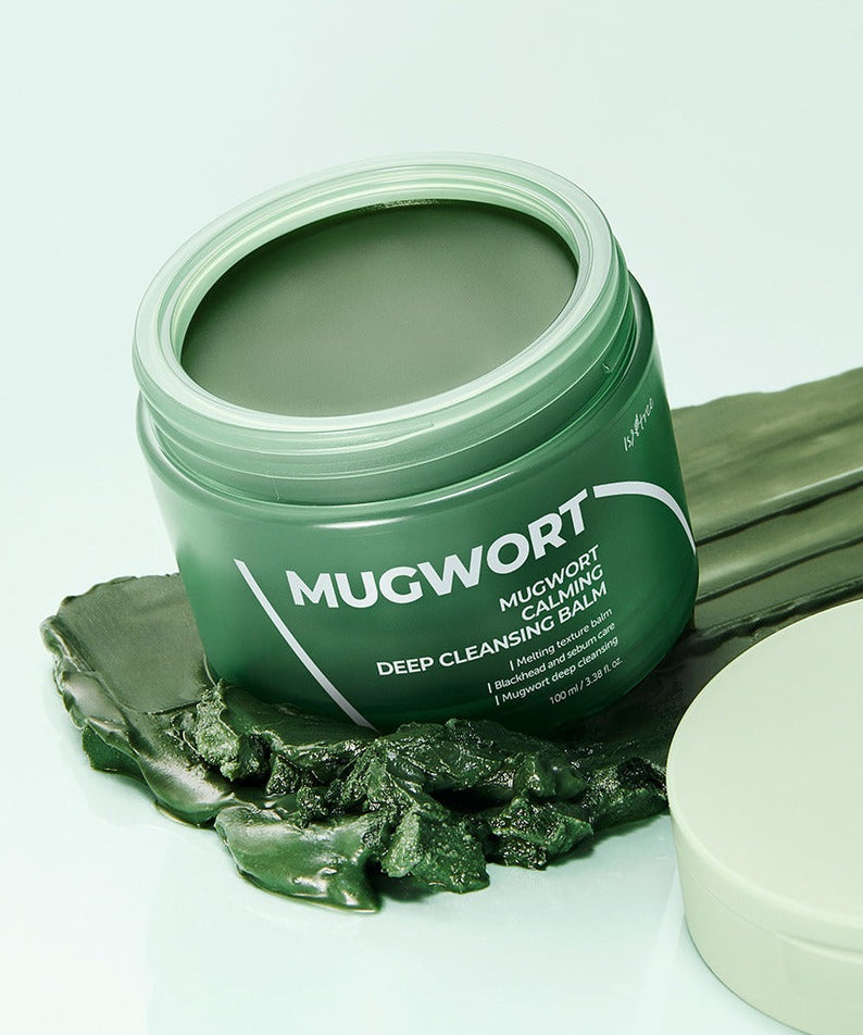 ISNTREE Mugwort Calming Deep Cleansing Balm 100g in open jar with green balm, displayed on a background with leaves.