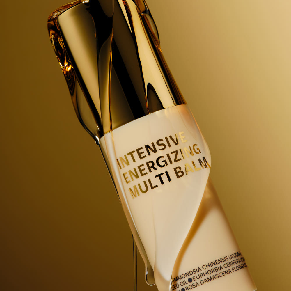 ISOI Intensive Energizing Multi-Balm 10g bottle on a gold background, highlighting the luxurious product design.