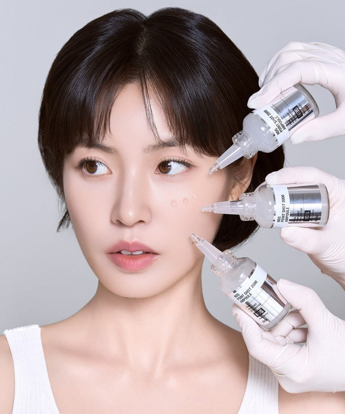 Person applying ISOI NDS Point Shot 2000 Ampoule 38ml on skin for skincare treatment.