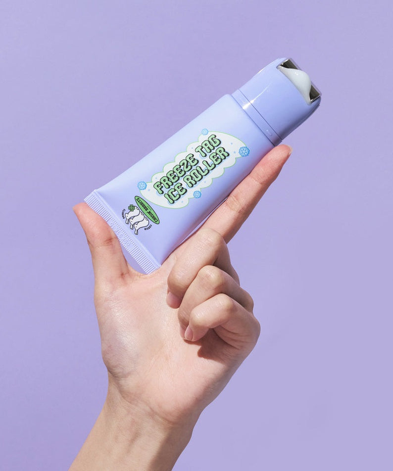 Hand holding IT'S SKIN Freeze Tag Ice Roller against purple background
