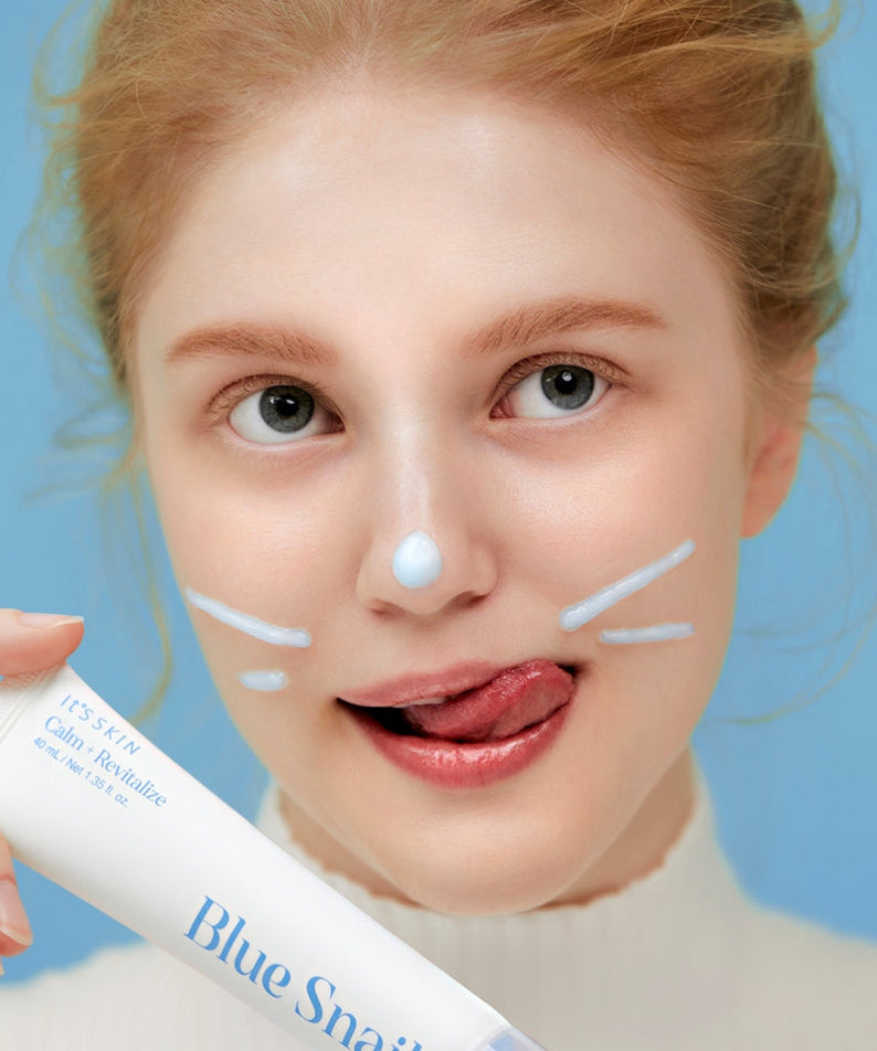 Woman applying IT'S SKIN Blue Snail Serum 40ml skincare product on face, promoting hydration and rejuvenation benefits.