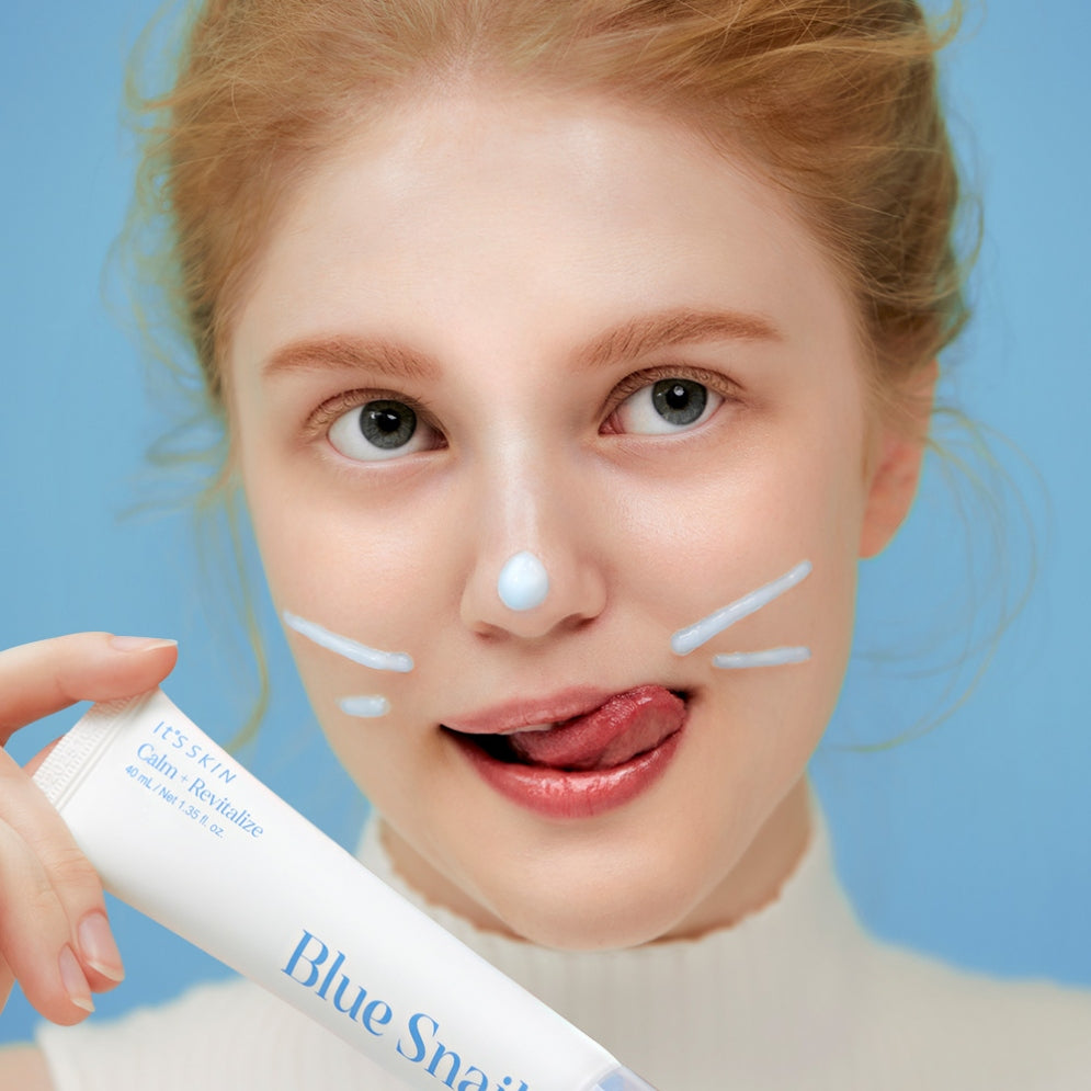 Woman applying IT'S SKIN Blue Snail Serum 40ml skincare product on face, promoting hydration and rejuvenation benefits.