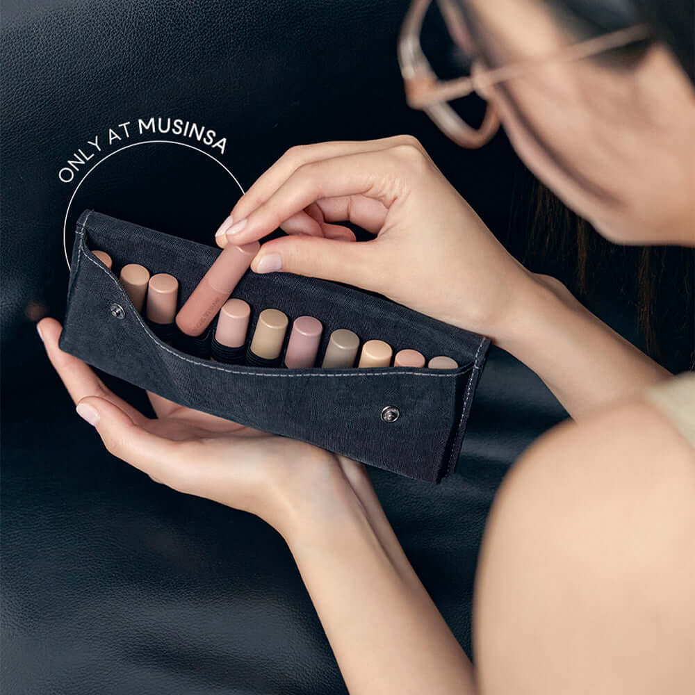 Close-up of a makeup pouch with several nude lipsticks being unzipped, available exclusively at Musinsa.