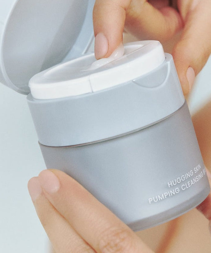 JAVIN DE SEOUL Hugging Skin Pumping Cleansing Balm 55g in hands, showcasing the product's easy-to-use design and packaging