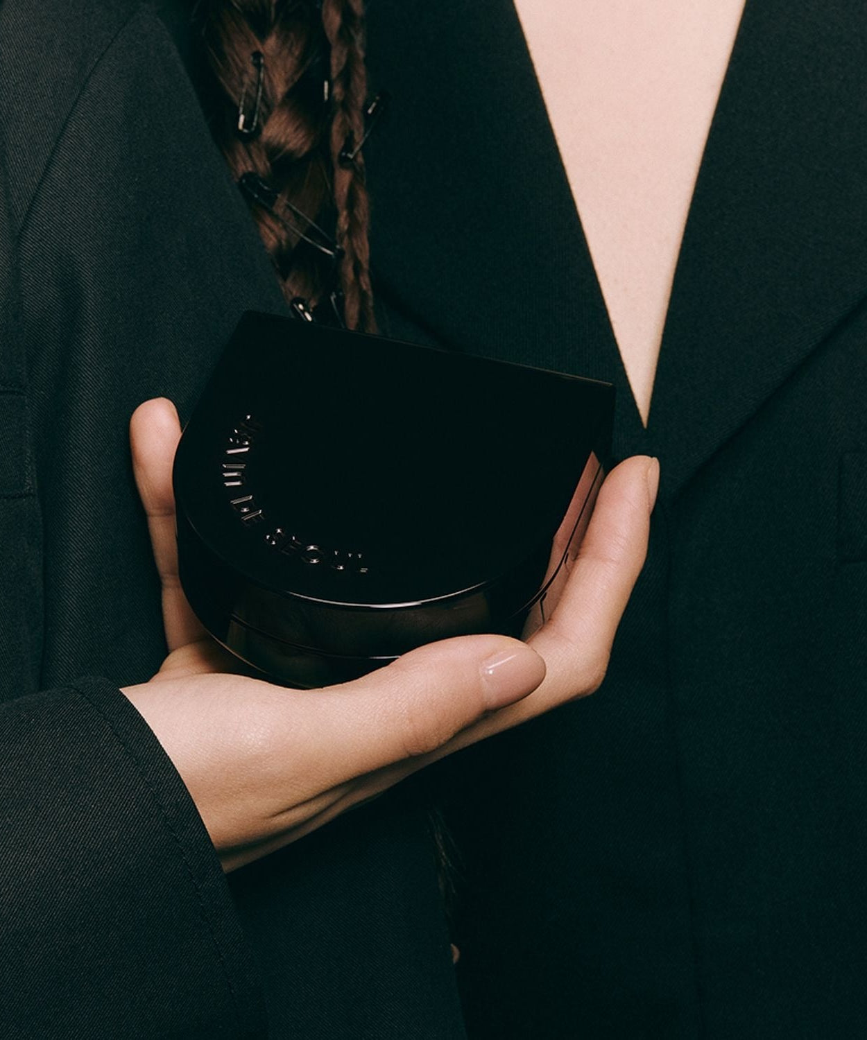 Person holding JAVIN DE SEOUL Wink Cushion Glow 16g compact in hand, showcasing sleek design.