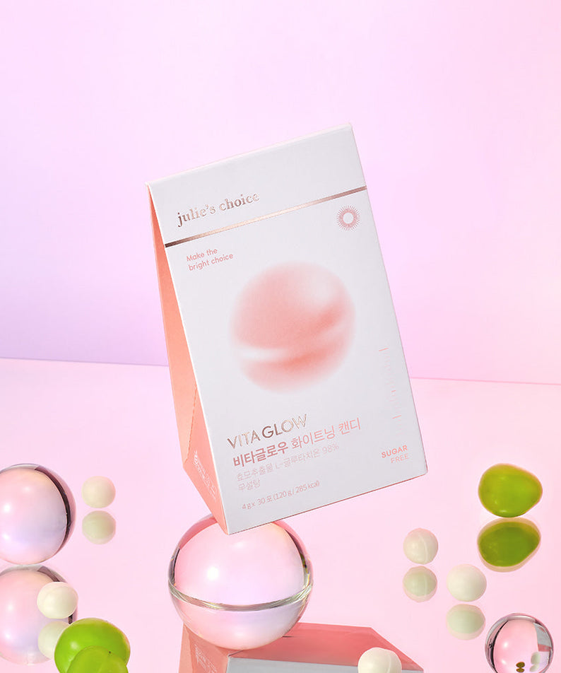 JULIE'S CHOICE Vita Glow Whitening Candy pink box with candies around on a reflective surface