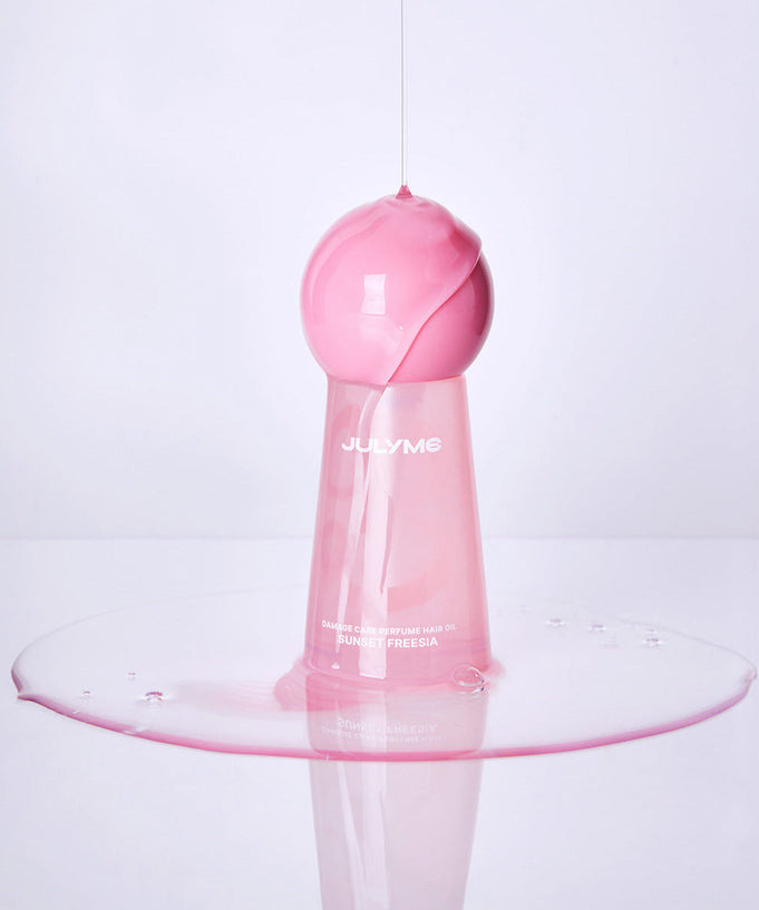 JULYME Damage Care Perfume Hair Oil 30ml (Sunset Freesia) pink bottle with spilled oil effect on white background