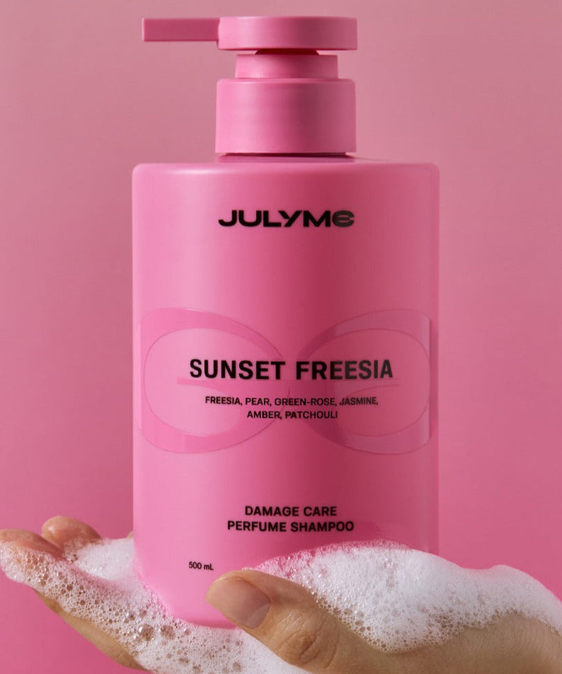 JULYME Damage Care Perfume Hair Shampoo 500ml in hand with pump dispenser, pink bottle showing sunset freesia label.