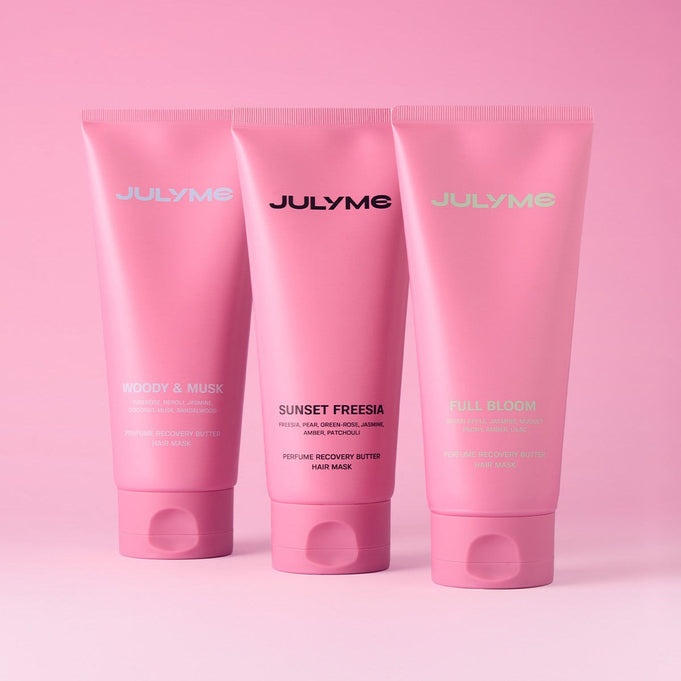 JULYME Perfume No-Wash Repair Hair Pack 150ml elegant pink tubes with various scents on a pink background.
