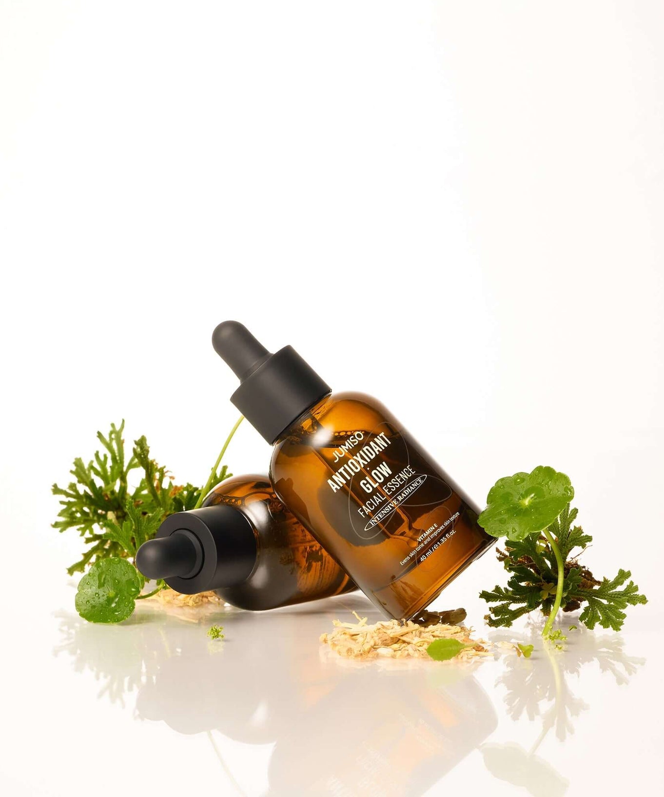 JUMISO Antioxidant Glow Facial Essence bottles with plants for skincare.
