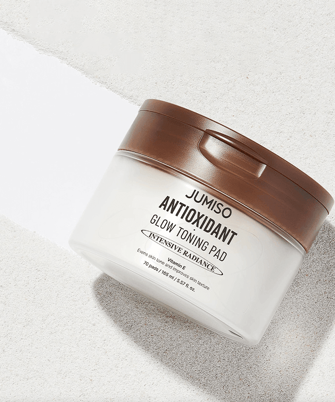 JUMISO Antioxidant Glow Toning Pads 70 Sheets in a white container with brown lid on a light background