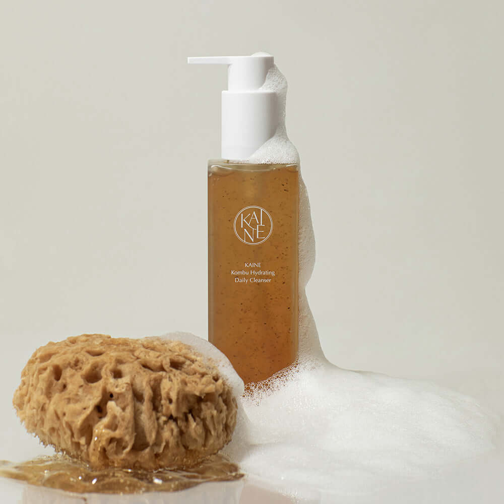 KAINE Kombu Hydrating Daily Cleanser 155g with foaming sponge beside the product bottle.