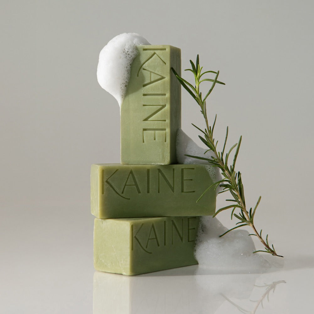 KAINE Rosemary Acne Mildly Acidic Cleansing Bar 100g displayed with soap bubbles and rosemary sprig