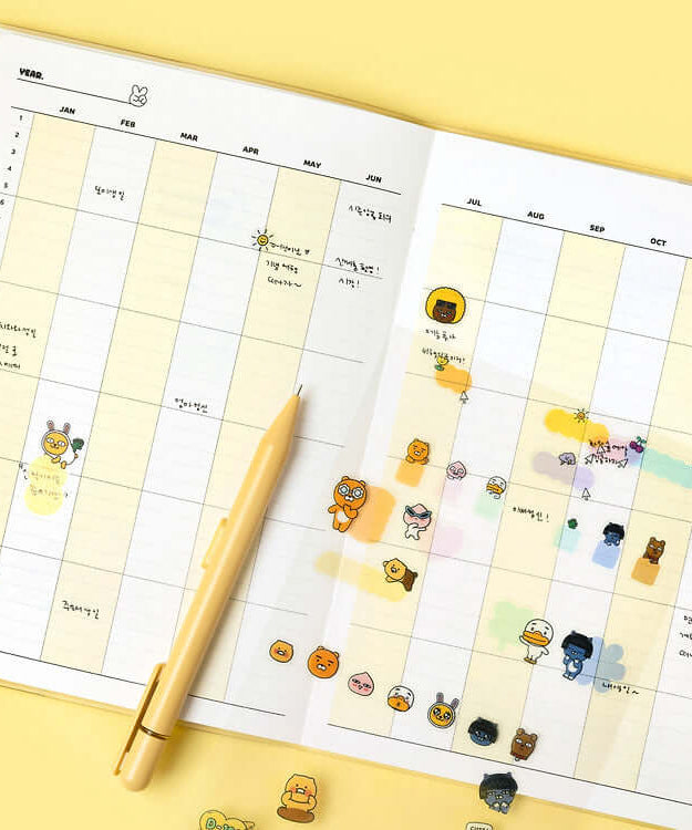 Open KAKAO FRIENDS Monthly Planner A5 with yellow pen and character stickers on monthly view pages.
