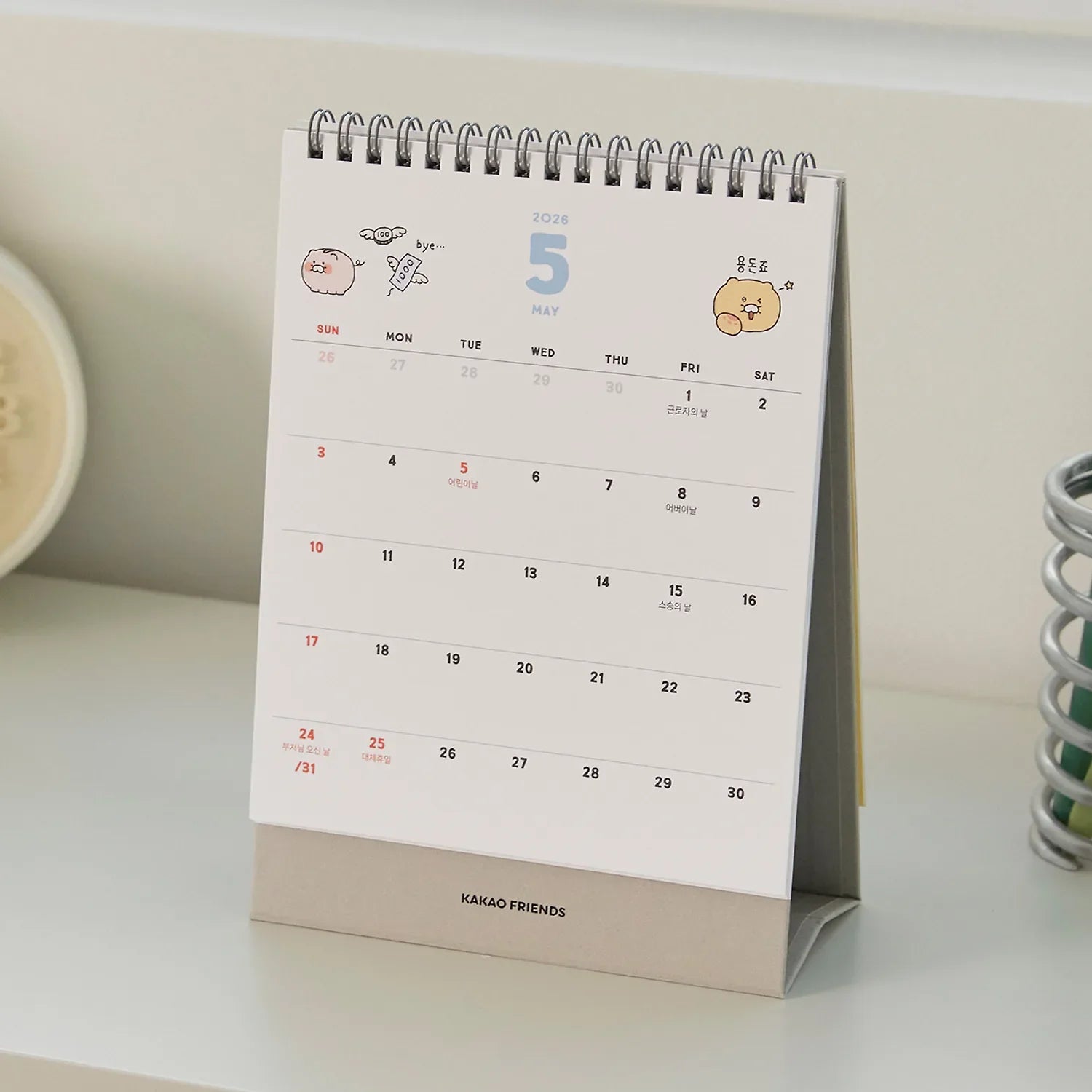 KAKAO FRIENDS Desk Calendar 2026 displayed on a white desk, showing the month of May with cartoon characters on the top.