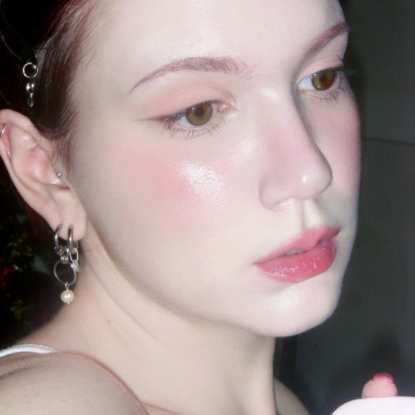 Woman wearing KEEP IN TOUCH GLossy Glow Marine Balm, showcasing shiny, moisturized skin with a dewy complexion.