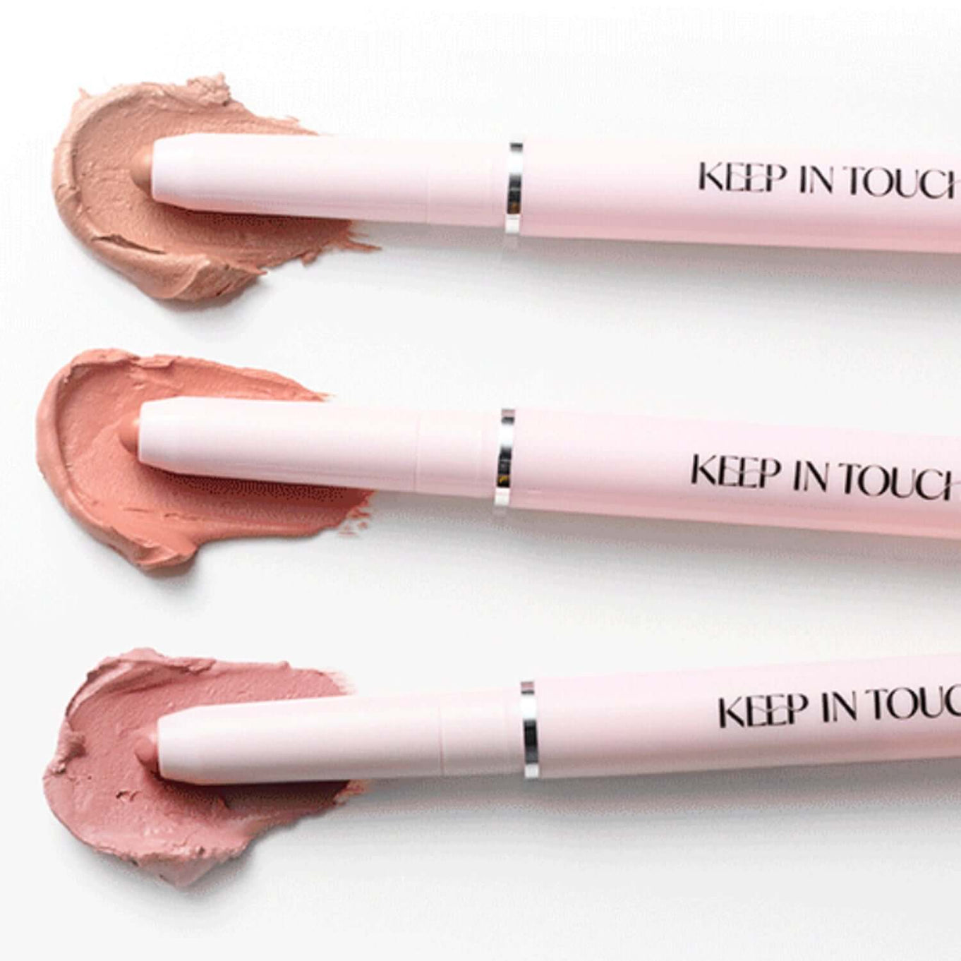 Three KEEP IN TOUCH Glow Lip Sealer Pencils in various shades on white background, showcasing product design and color variety.