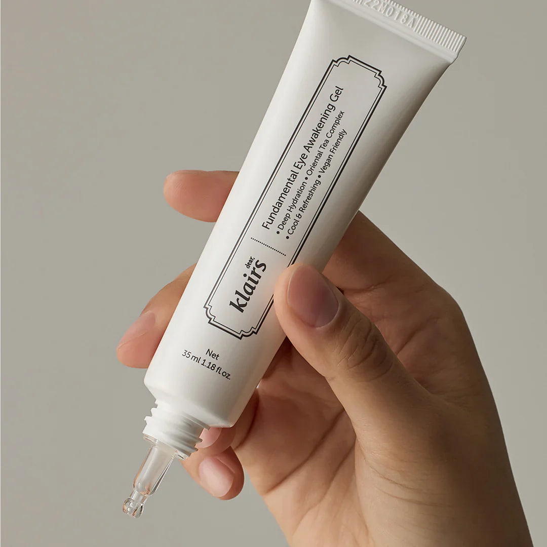 Hand holding KLAIRS Fundamental Eye Awakening Gel 35ml tube against a neutral background.