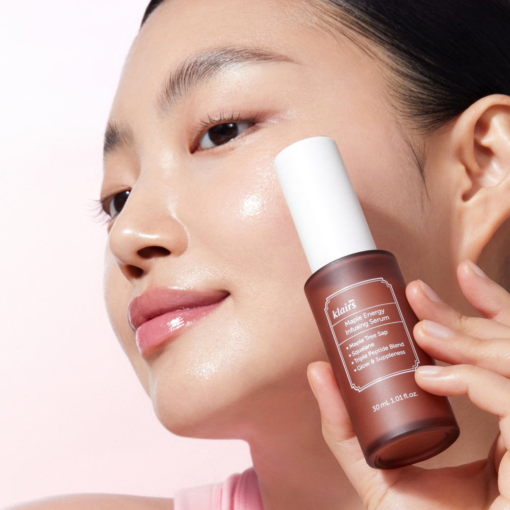 Woman holding KLAIRS Maple Energy Infusing Serum 30ml against her face