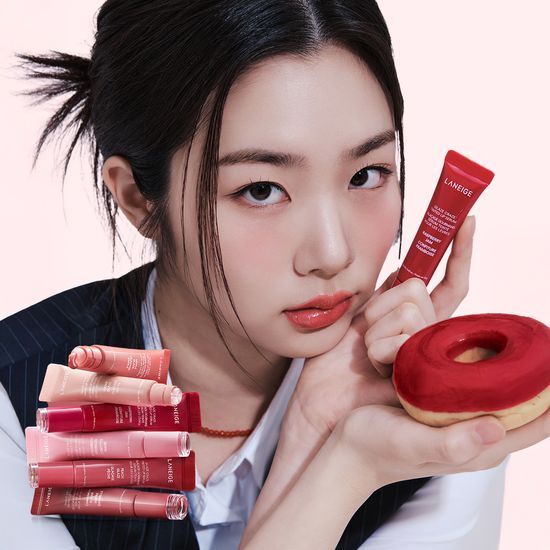 Model holding LANEIGE Glaze Craze Tinted Lip Serum with donut, showcasing product shades.