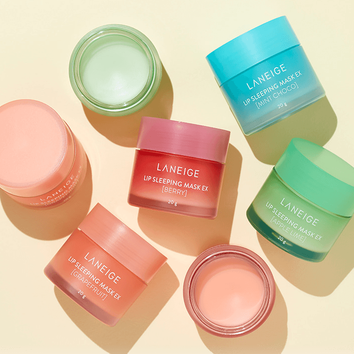 Assorted LANEIGE Lip Sleeping Mask EX jars on display in different colors and flavors, including berry, grapefruit, and mint choco.