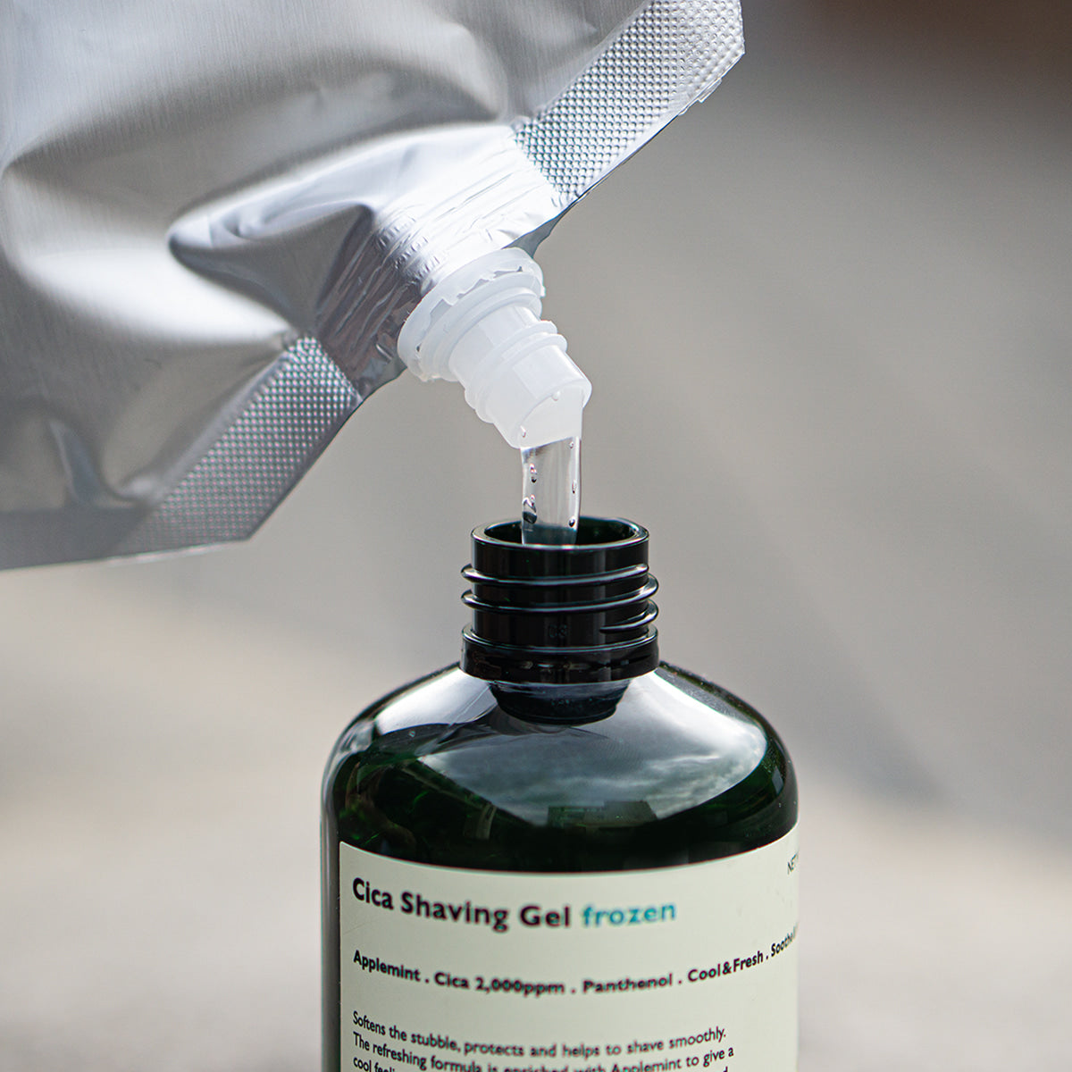 LAZY SOCIETY Frozen Shaving Gel Refill Set - Gentleman Korea refill pouch pouring into dark green shaving gel bottle