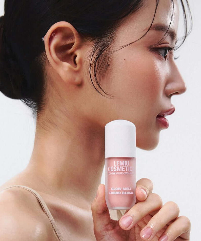 Side profile of a woman holding LEMIU Glow Melt Liquid Blush to her cheek