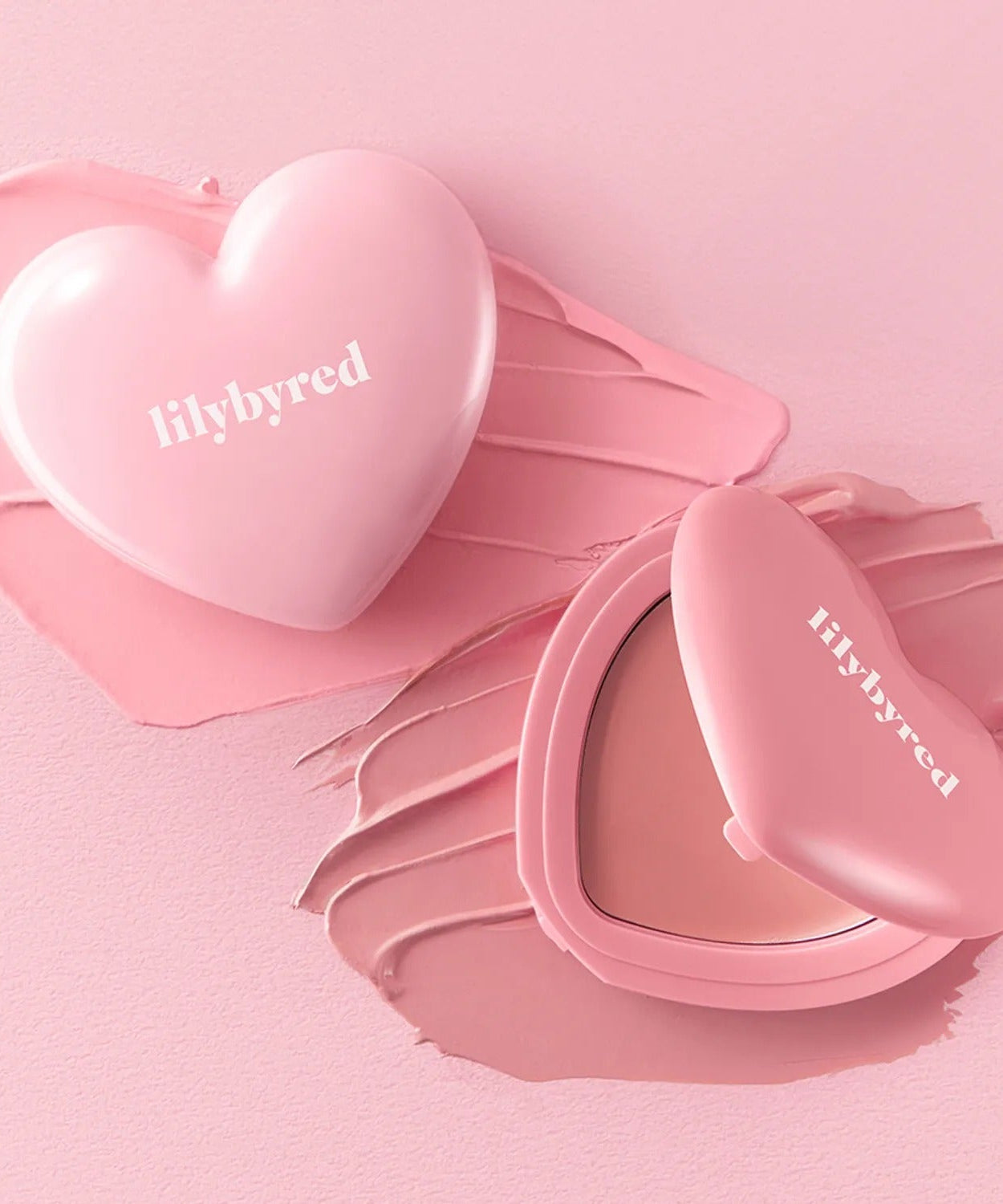 LILYBYRED Love Beam Cheek Balm in heart-shaped blush container on pink background