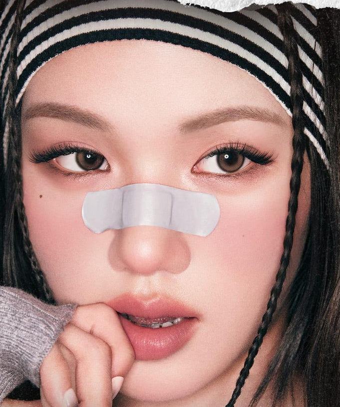 Fashionable model with a nose strip and striped headband for skincare advertisement.