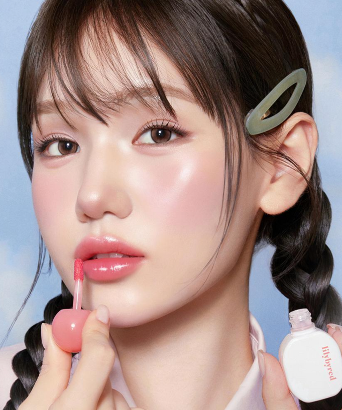 Model applying LILIBYRED Sugar Wrapping Tint Gloss for a glossy lip finish.