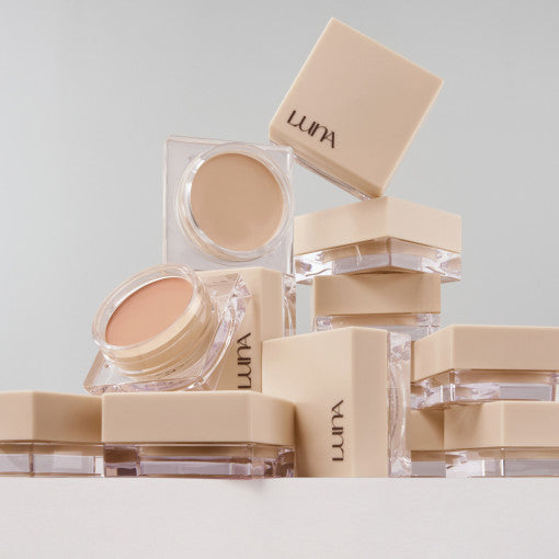 Stack of LUNA Conceal Pot cosmetics in beige packaging, showcasing product design and color.