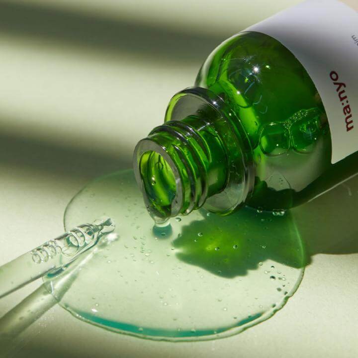 MANYO Bifida Cica Herb Serum 50ml bottle with spilled serum showcasing skincare product texture.