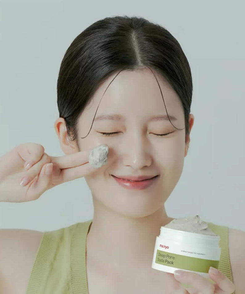 Smiling woman applying MANYO Deep Pore Soda Pack 110ml to her face, showcasing skincare benefits.