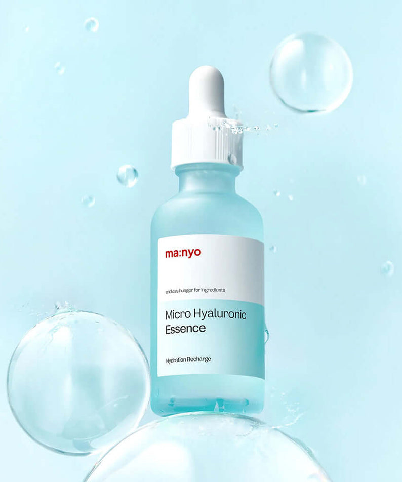Bottle of MANYO Micro Hyaluronic Essence 50ml surrounded by bubbles on a blue background.