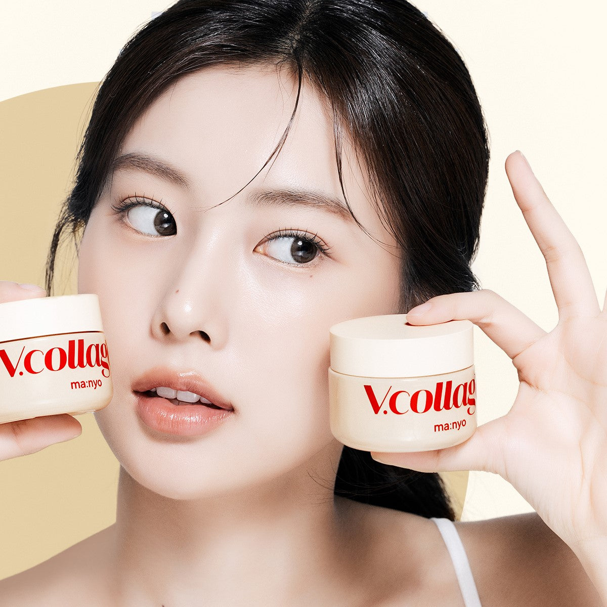 Woman holding MA:NYO V.Collagen Heart Fit Cream 50ml containers, showcasing product packaging.