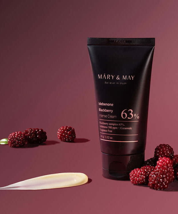 MARY & MAY Idebenone Blackberry Intense Cream displayed with blackberries on a burgundy background.